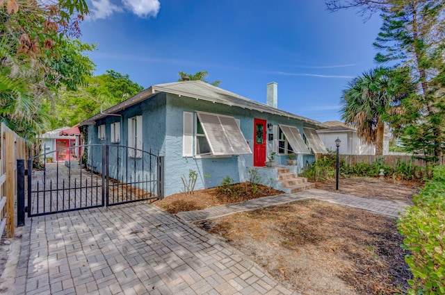 view of front of home featuring a gate, fence, and stucco siding