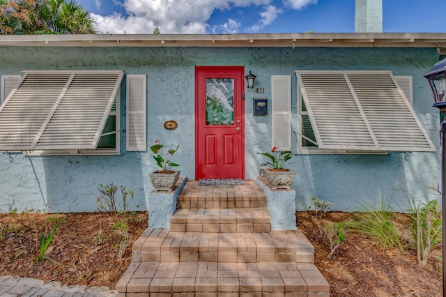 doorway to property with stucco siding