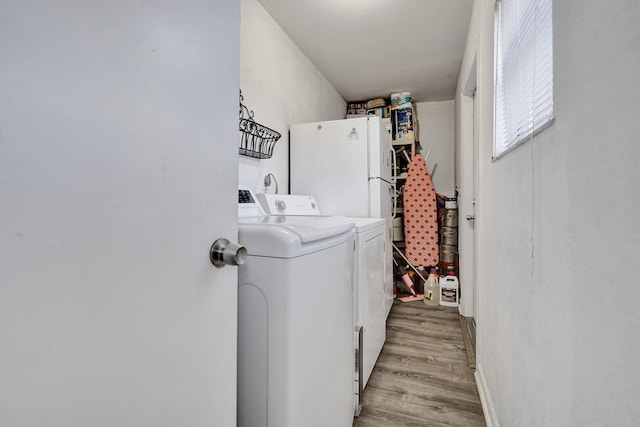 laundry room featuring laundry area, separate washer and dryer, and light wood finished floors