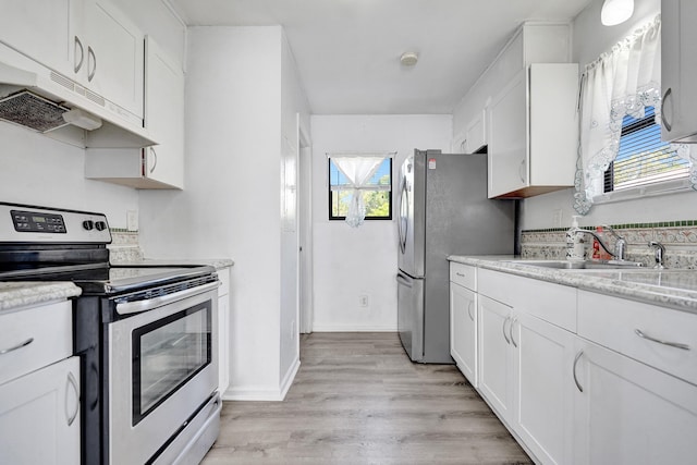 kitchen featuring under cabinet range hood, a sink, white cabinets, appliances with stainless steel finishes, and light wood finished floors