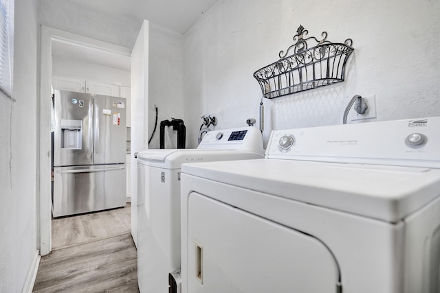 laundry room featuring laundry area, light wood finished floors, and independent washer and dryer