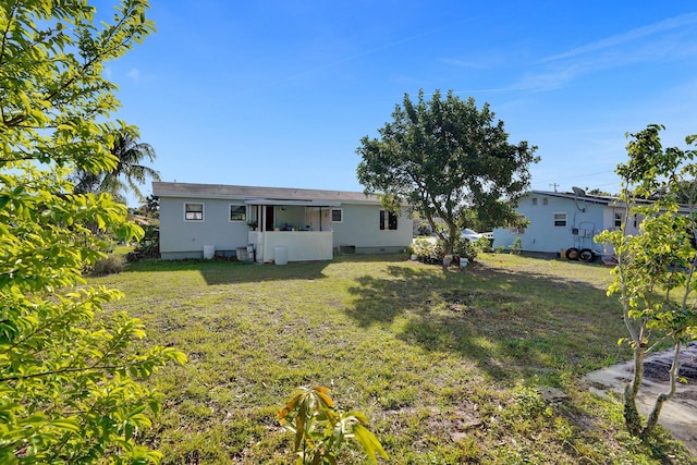 rear view of property featuring a lawn