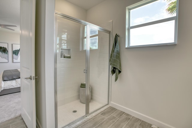 bathroom featuring a shower stall, wood tiled floor, baseboards, and ensuite bathroom