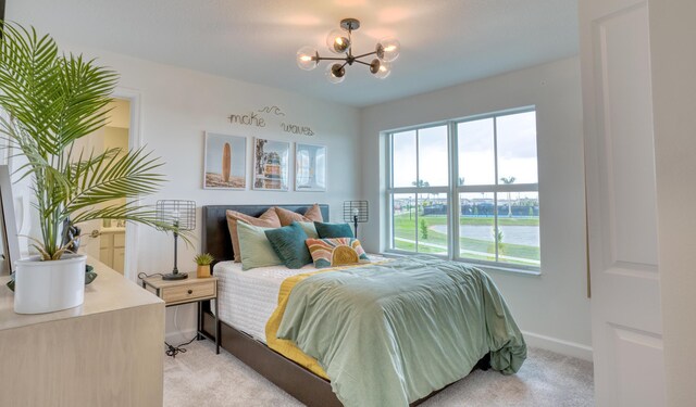 bedroom with light carpet, baseboards, and a chandelier