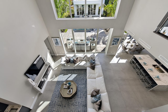 living room featuring a high ceiling and baseboards