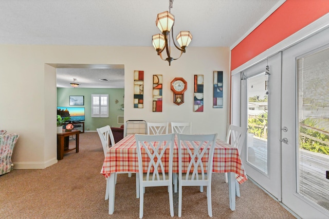 carpeted dining space with baseboards, french doors, a textured ceiling, and an inviting chandelier