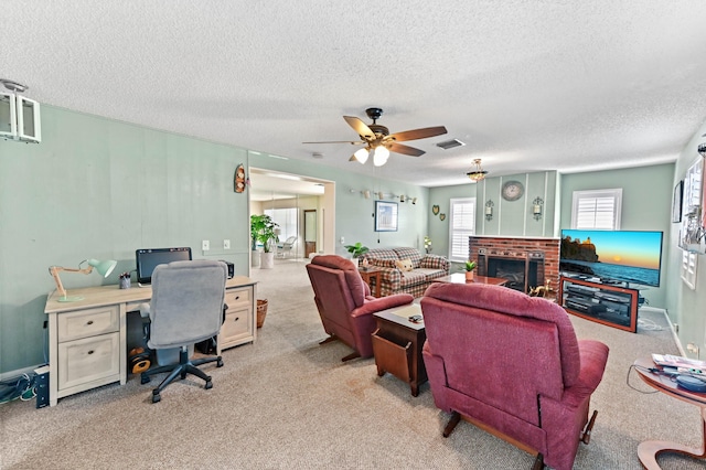 living area with a ceiling fan, visible vents, a fireplace, and light carpet