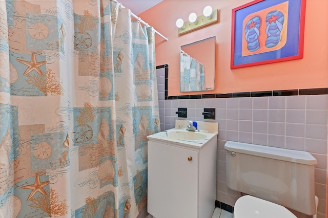 full bath featuring tile walls, toilet, wainscoting, vanity, and a shower with curtain