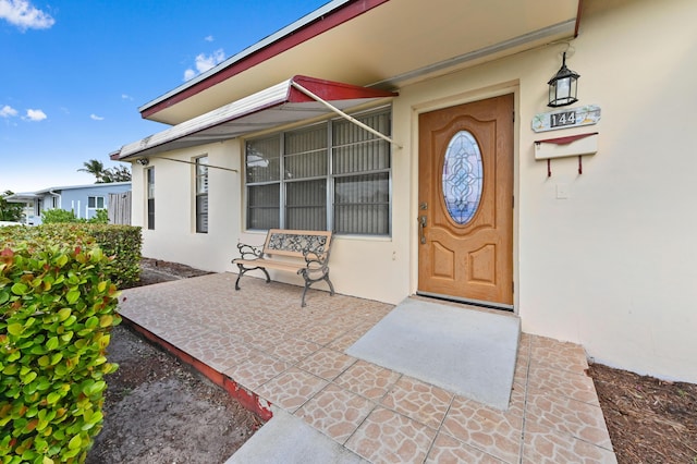 view of exterior entry featuring stucco siding