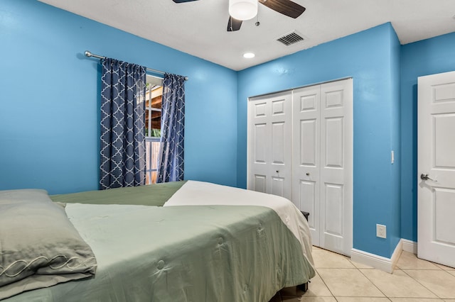 bedroom featuring light tile patterned floors, ceiling fan, visible vents, baseboards, and a closet