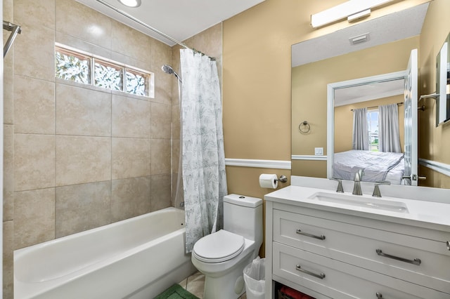 ensuite bathroom featuring a healthy amount of sunlight, shower / bathtub combination with curtain, toilet, and vanity