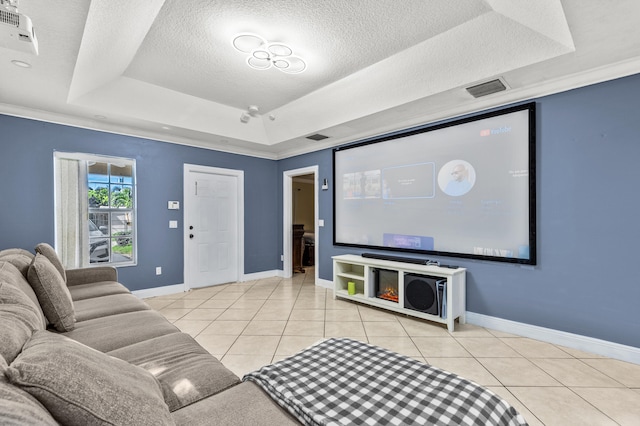 tiled home theater room featuring visible vents, a raised ceiling, and a textured ceiling