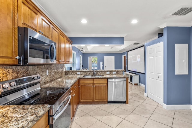 kitchen with appliances with stainless steel finishes, a sink, visible vents, and brown cabinets