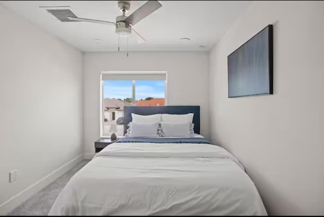 bedroom featuring baseboards, visible vents, a ceiling fan, and light colored carpet