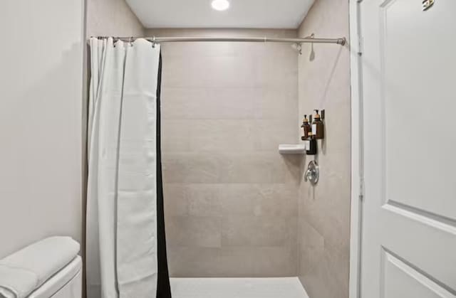 bathroom with a stall shower and toilet