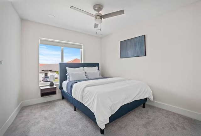 bedroom with light carpet, a ceiling fan, and baseboards