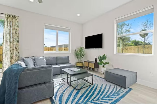 living room featuring a ceiling fan, recessed lighting, baseboards, and light wood finished floors