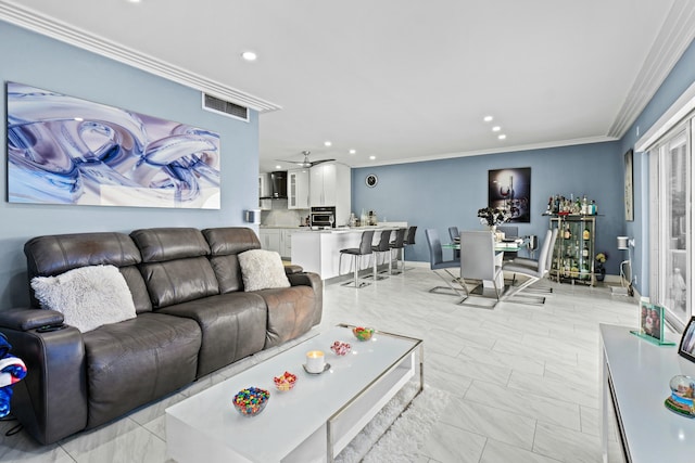 living area featuring baseboards, visible vents, ceiling fan, crown molding, and recessed lighting