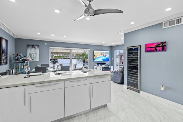 kitchen featuring wine cooler, visible vents, ornamental molding, a ceiling fan, and white cabinetry