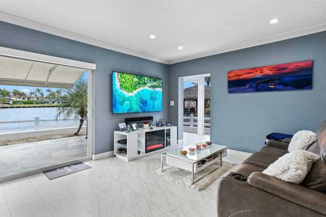 living room with crown molding, recessed lighting, a water view, a glass covered fireplace, and baseboards