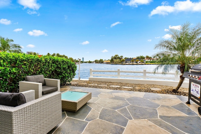 view of patio with a water view and fence