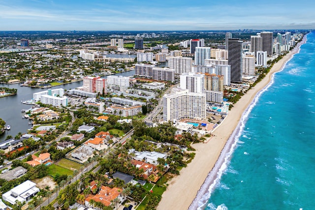 drone / aerial view with a view of city, a water view, and a beach view