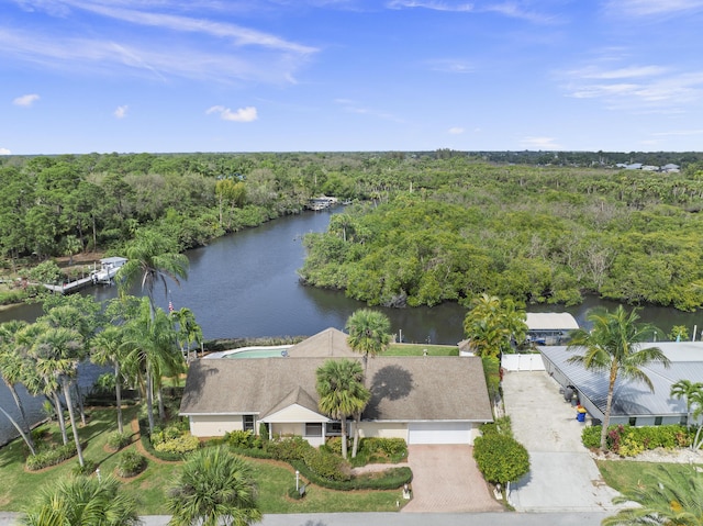 drone / aerial view featuring a water view and a wooded view