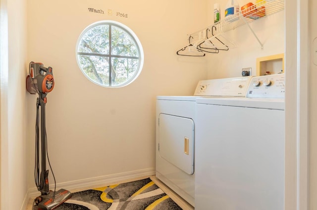 laundry room featuring laundry area, baseboards, and washing machine and clothes dryer