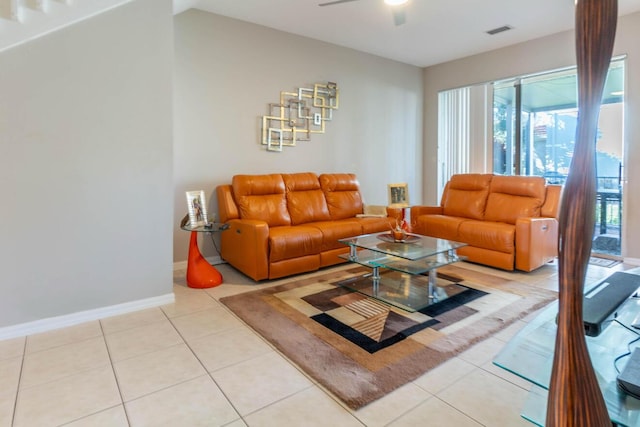 living area featuring light tile patterned floors, ceiling fan, visible vents, and baseboards