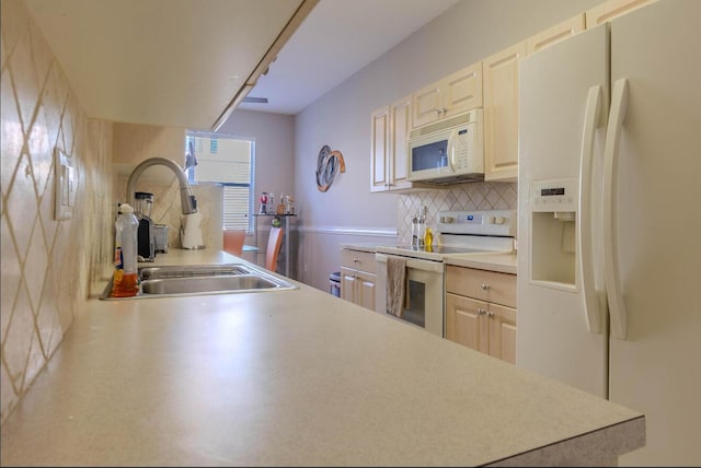 kitchen with a wainscoted wall, white appliances, a sink, light countertops, and decorative backsplash