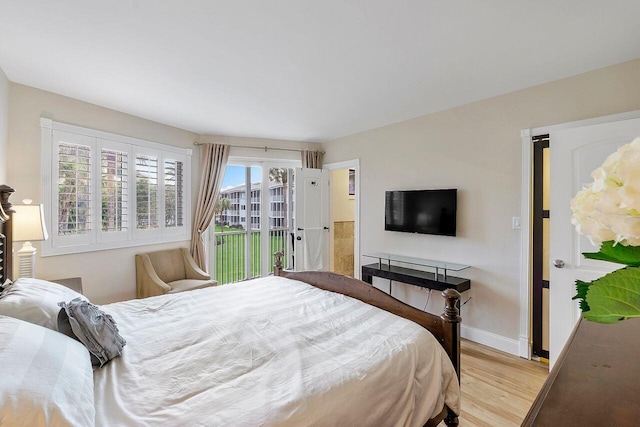 bedroom featuring access to outside, light wood-style flooring, and baseboards