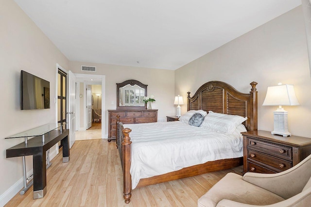 bedroom with light wood finished floors, visible vents, and baseboards