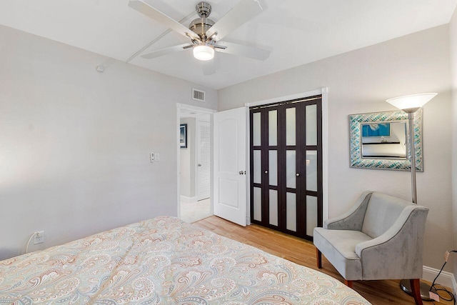 bedroom featuring visible vents, ceiling fan, and light wood-style flooring