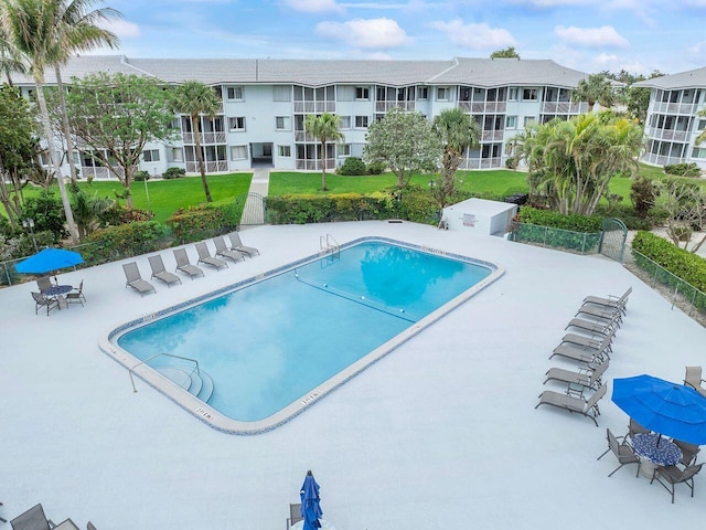 community pool with a patio and a yard