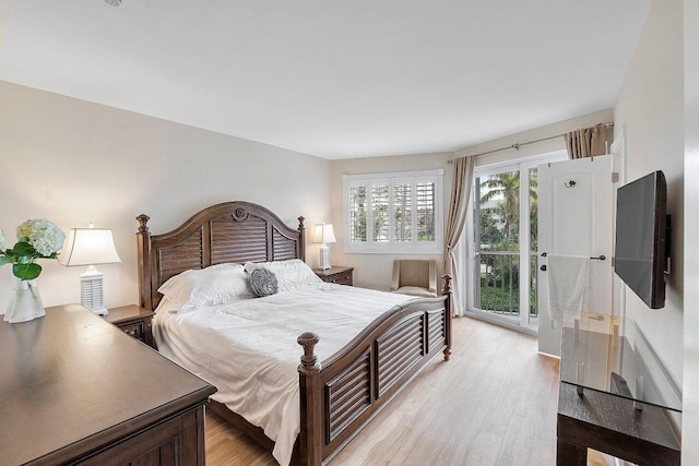 bedroom with access to outside and light wood-style flooring