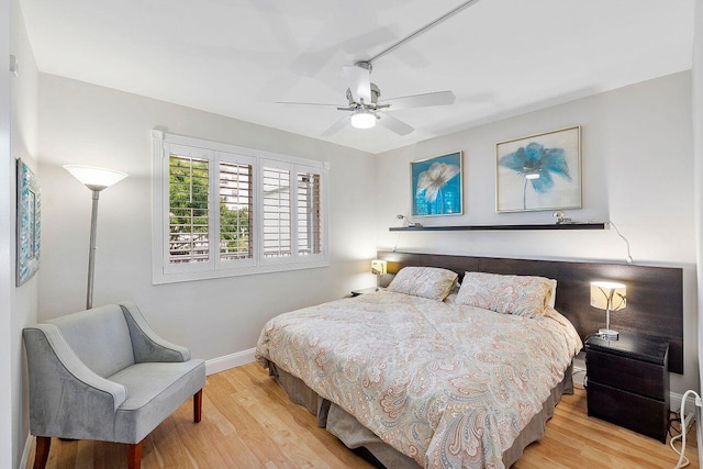 bedroom featuring ceiling fan, baseboards, and wood finished floors