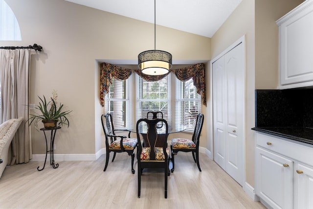 dining area with vaulted ceiling, light wood-type flooring, and baseboards