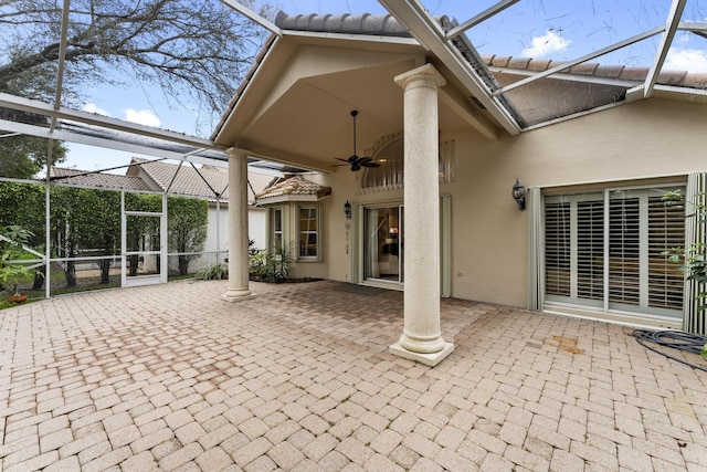 view of patio with ceiling fan and glass enclosure