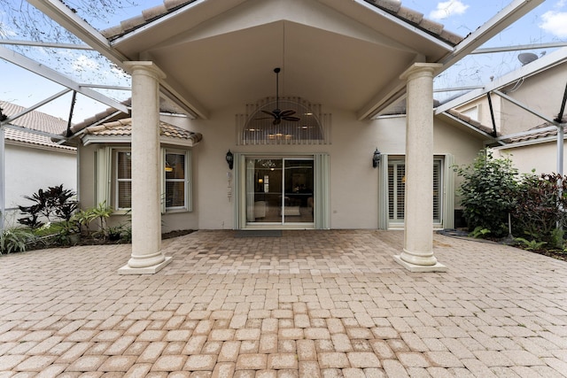 doorway to property with a patio area, stucco siding, a ceiling fan, and a tiled roof