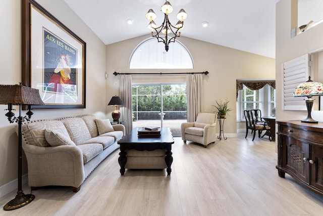 living room featuring light wood finished floors, baseboards, high vaulted ceiling, and an inviting chandelier