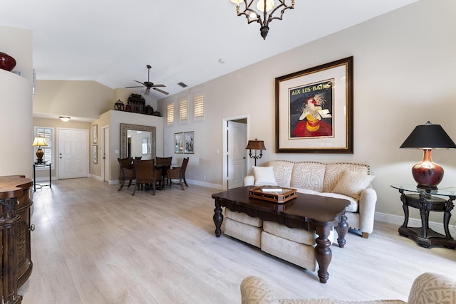 living room with visible vents, baseboards, a ceiling fan, lofted ceiling, and light wood-style flooring