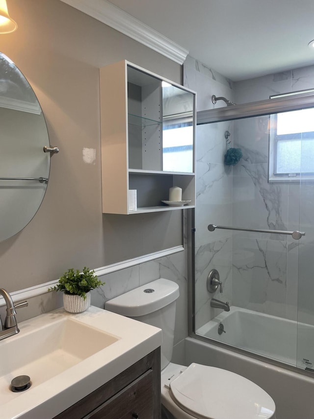 bathroom with toilet, combined bath / shower with glass door, crown molding, and vanity