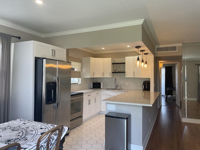 kitchen with visible vents, appliances with stainless steel finishes, white cabinetry, a sink, and a peninsula