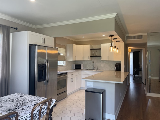 kitchen featuring open shelves, stainless steel appliances, light countertops, white cabinetry, and a peninsula