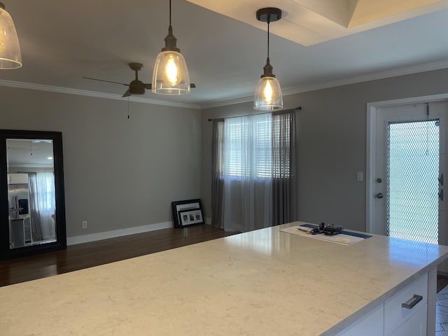 kitchen featuring dark wood-type flooring, white cabinetry, ornamental molding, and baseboards