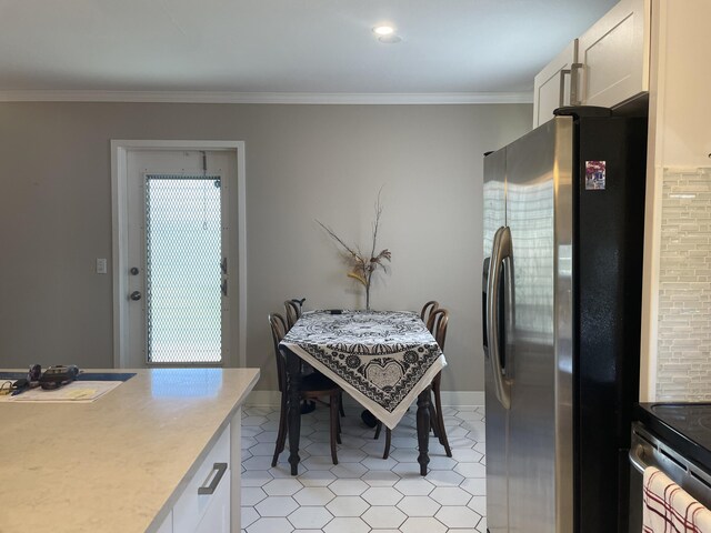 dining space featuring a wealth of natural light, crown molding, baseboards, and light tile patterned floors