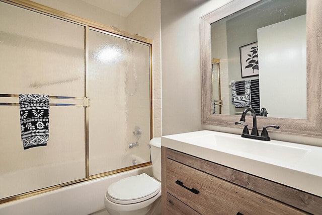 bathroom with toilet, combined bath / shower with glass door, and vanity