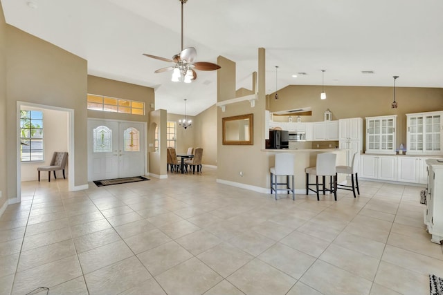 961 SW Haas Ave, Port Saint Lucie, FL 34953 - living room with light tile patterned flooring, a ceiling fan, high vaulted ceiling, and a chandelier