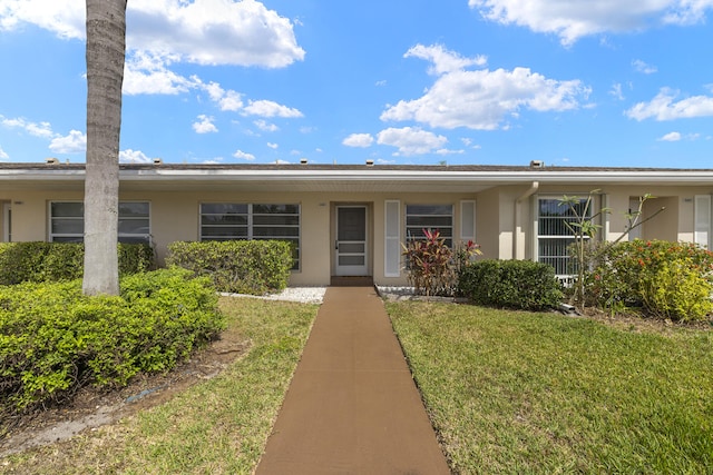 single story home featuring a front lawn and stucco siding