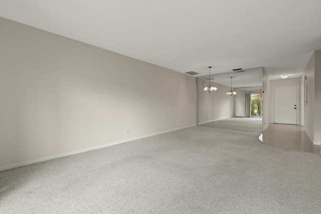 spare room featuring baseboards, visible vents, and carpet flooring